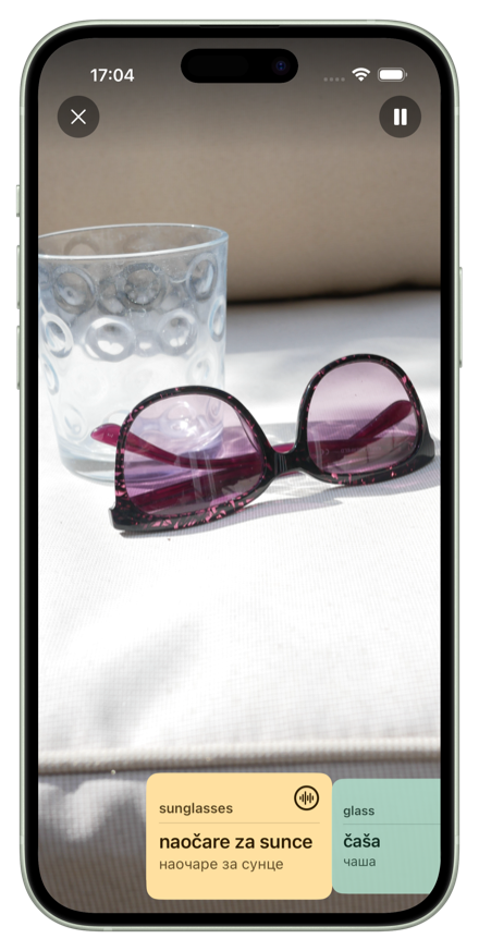 VoxieCam camera view identifying sunglasses and a glass, showing translation cards in Serbian